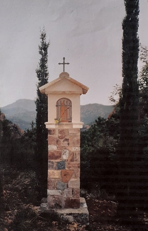 Oratoire en pierre surmonté d'une croix, entre deux cyprès