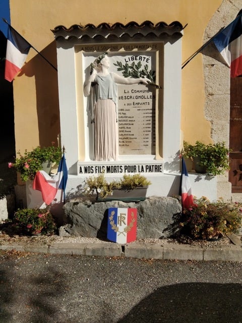 Monument aux morts pavoisé de drapeaux tricolores, « À nos fils morts pour la patrie »
